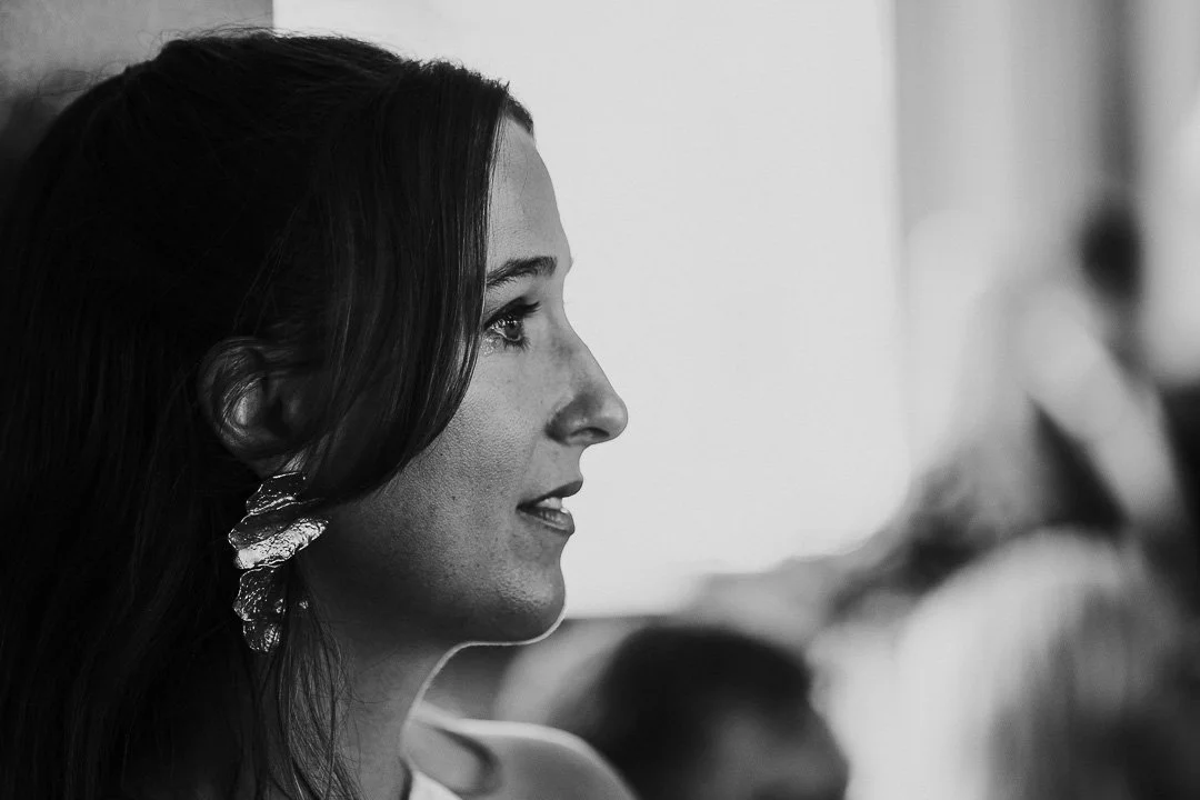 A Black & White image of a guest watching the ceremony with a tear in her eye at a Hampton Court House Wedding.