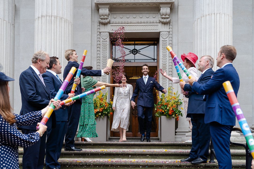 Wedding couple just walking into confetti line who are lined up on the steps outside at the Old Marylebone Town Hall Wedding.