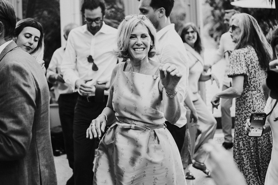 One guest at the centre of the image dancing and smiling at the camera on the dancefloor at a Hampton Court House Wedding.
