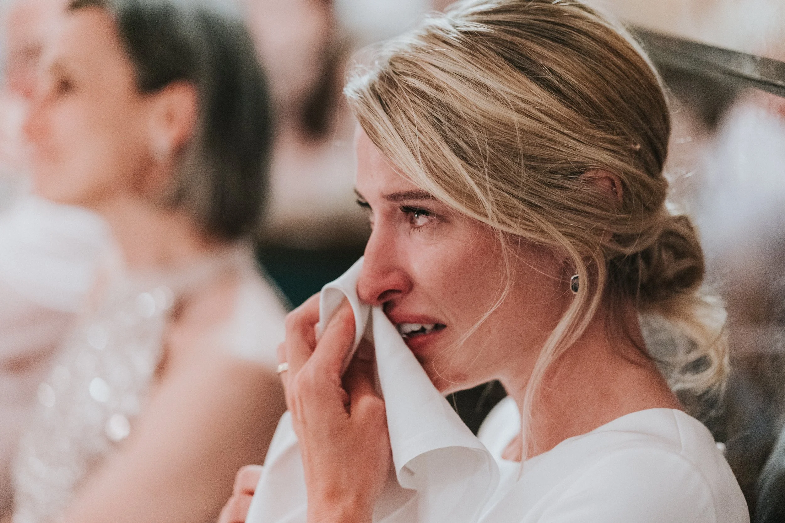 Bride crying after listening to speech at The Ivy Restaurant at a Old Marylebone Town Hall Wedding.