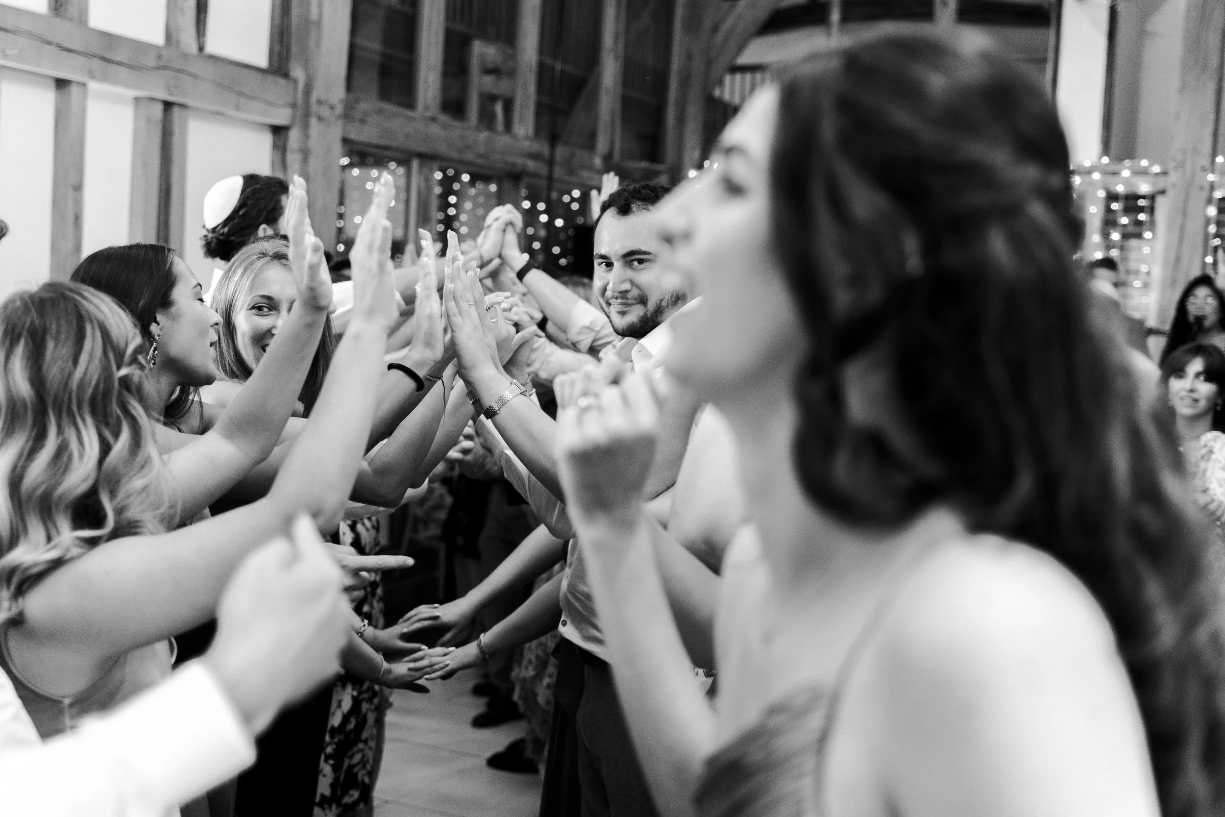 Wedding guests making a tunnel for the wedding couple to walk through  at a Micklefield Hall Wedding