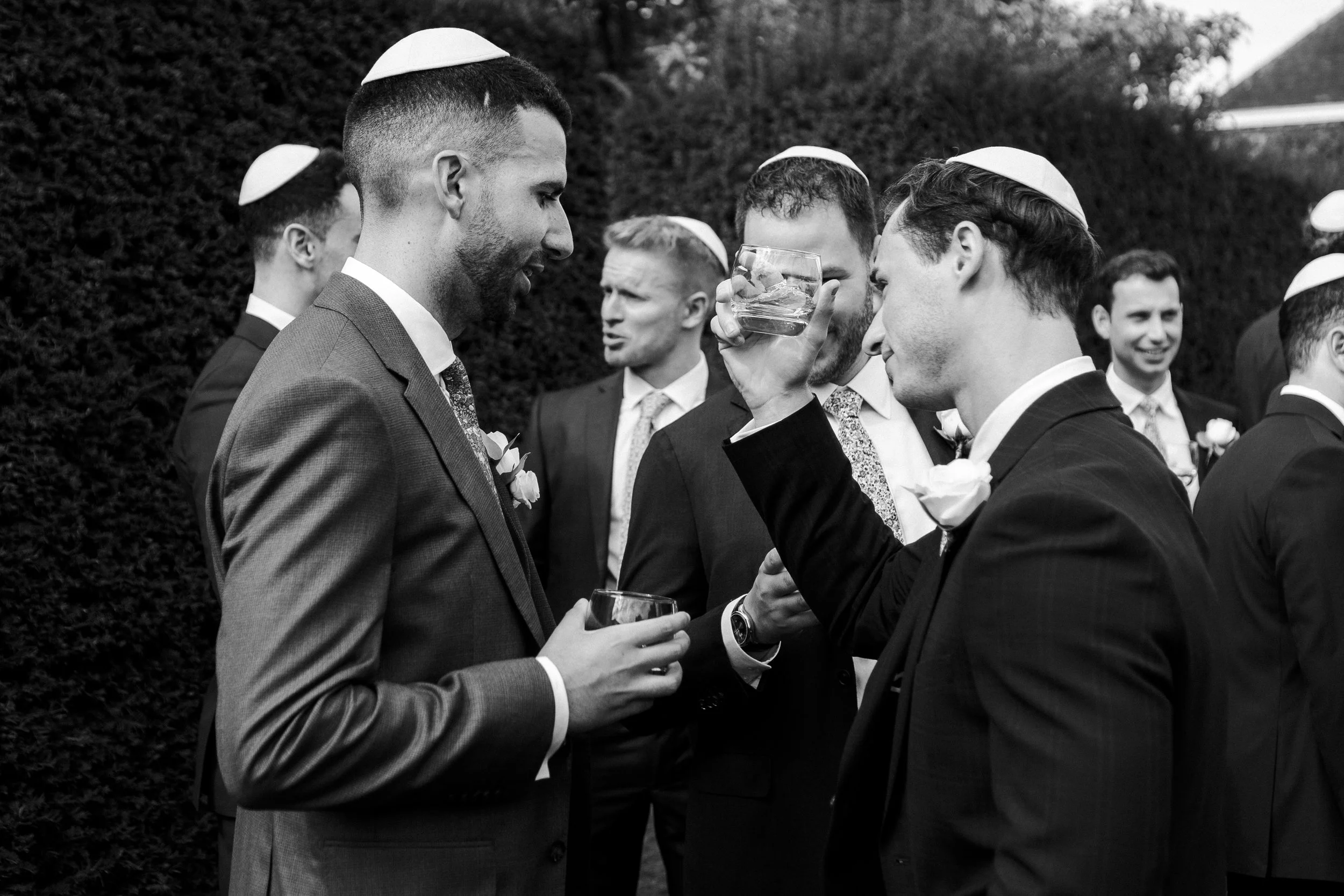 Guest showing a glass with a drink to the groom at a Micklefield Hall Wedding