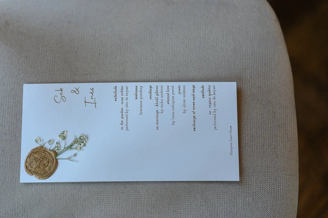 An invitation on a chair at a Hampton Court House Wedding.
