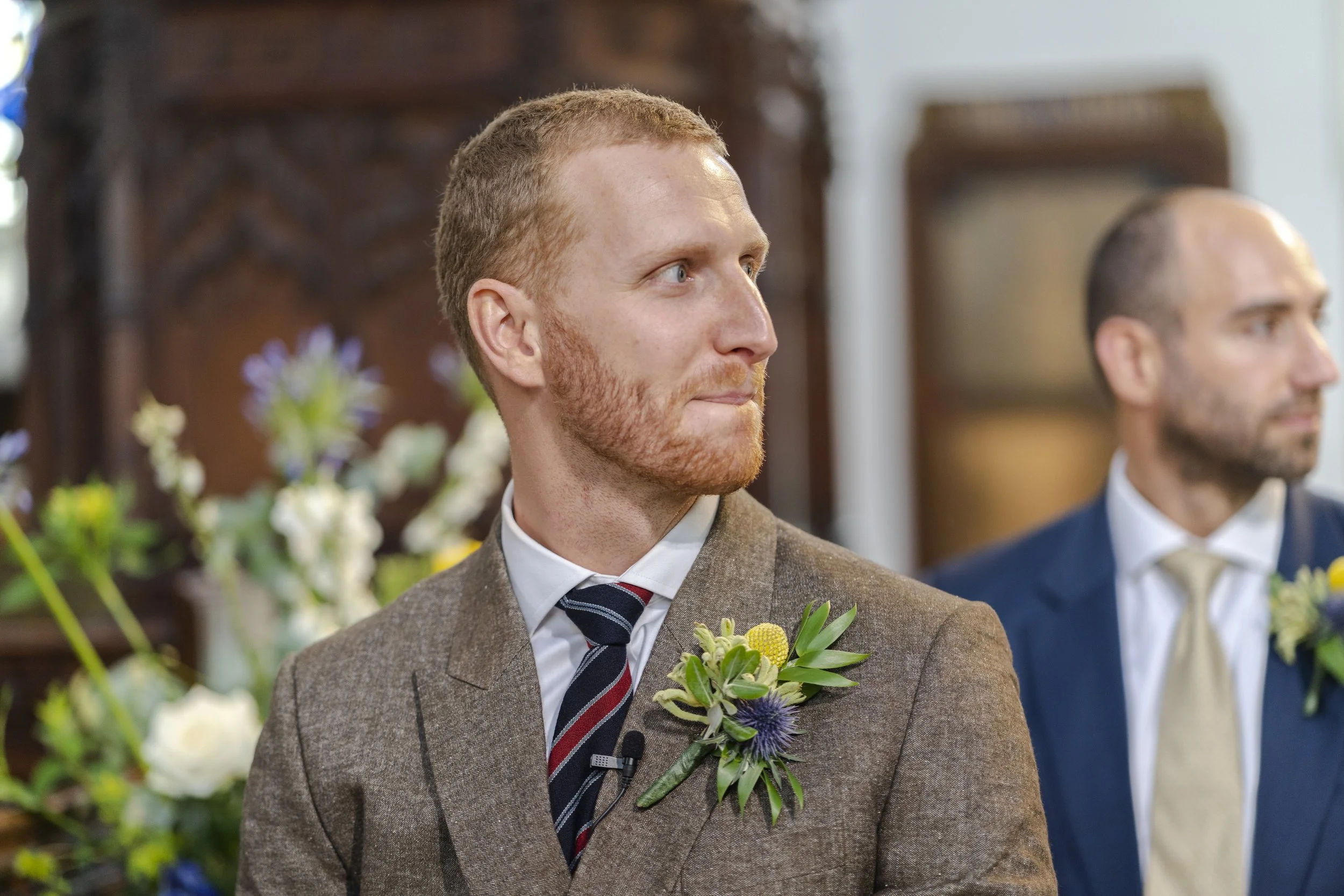 Groom looking down the aisle where the Bride is walking down out of shot in St Michael's Church at a Highgate, London Wedding