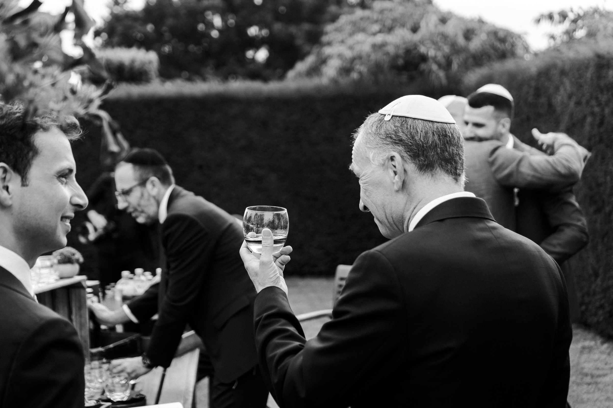 Guest looking at his glass of drink with a smile on his face at a Micklefield Hall Wedding