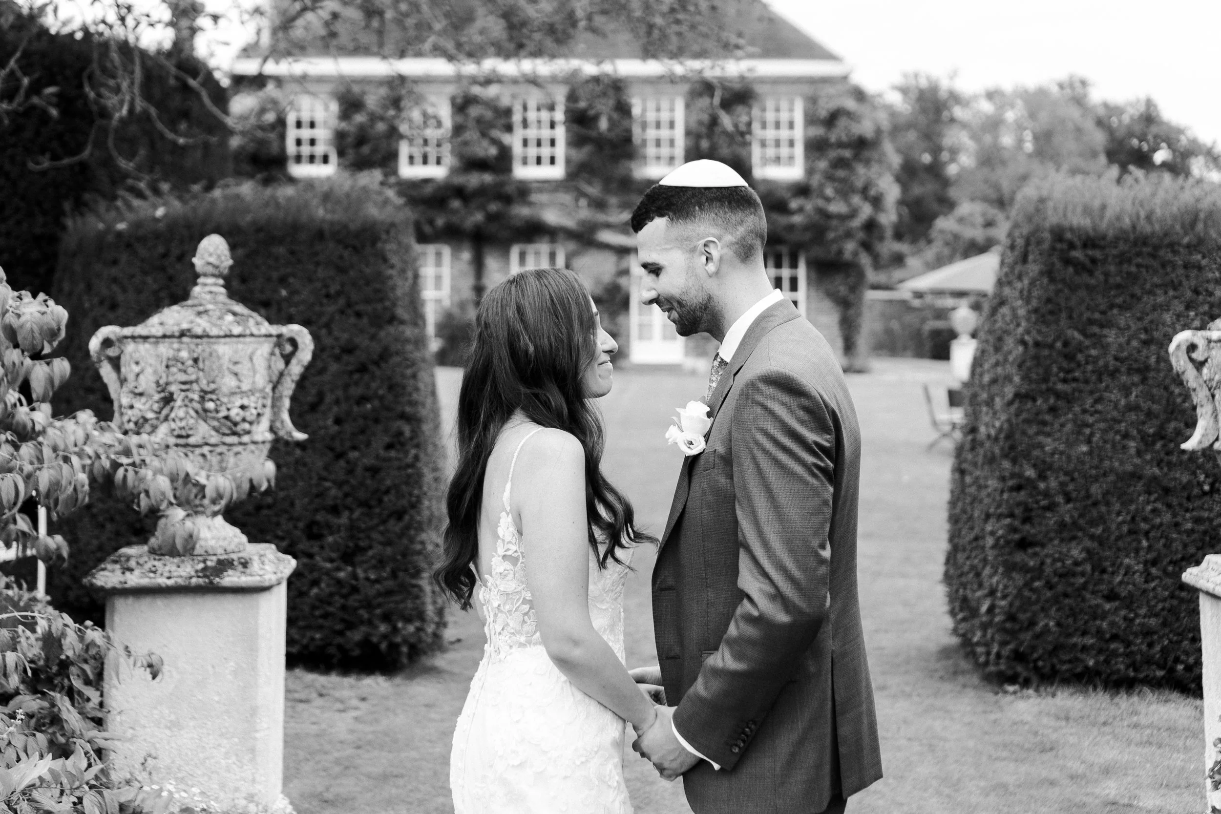 Couple standing together and smiling at each other at their First Look at a Micklefield Hall Wedding