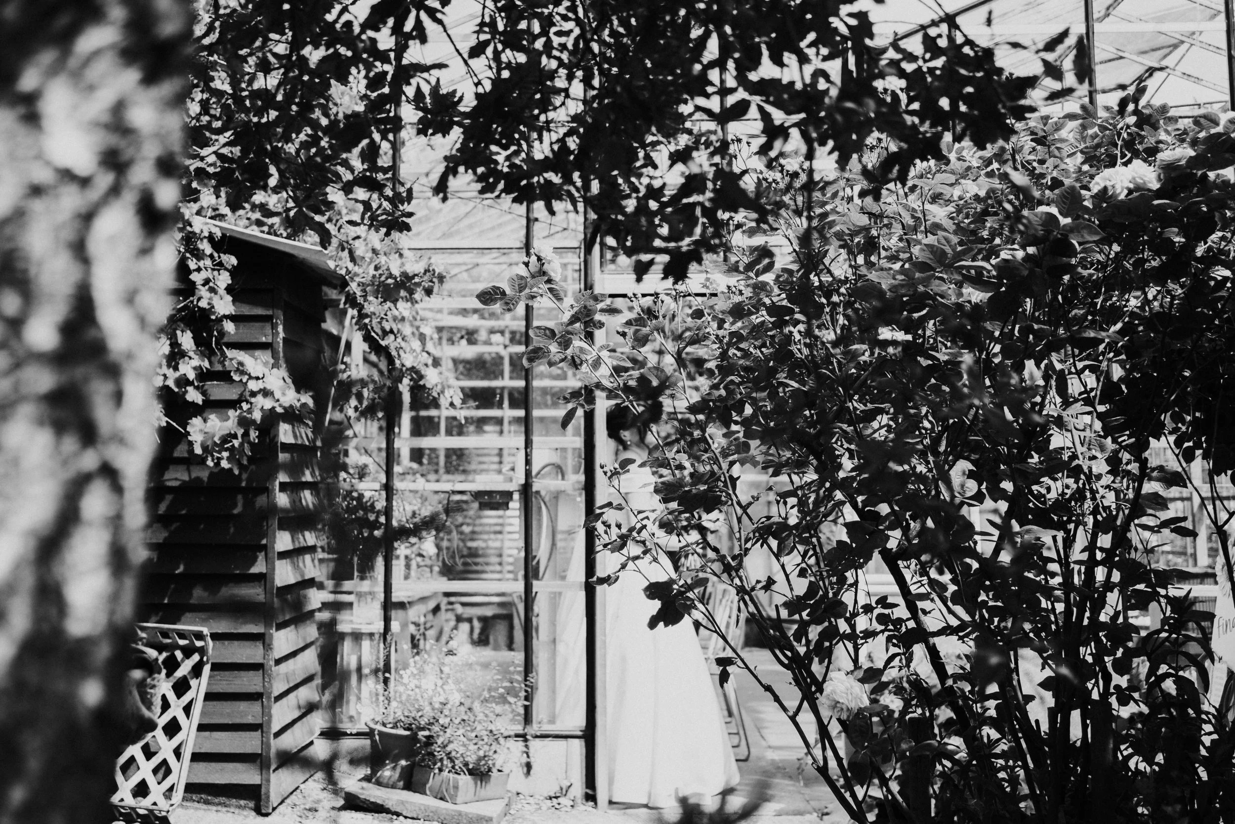Slight view of the Bride from the Wedding Reception Room in the Greenhouse at a Worton Kitchen Garden, Oxfordshire Wedding.