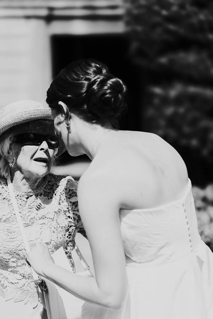 Bride embracing her Grandma and she looks up at the bride at a Hampton Court House Wedding.