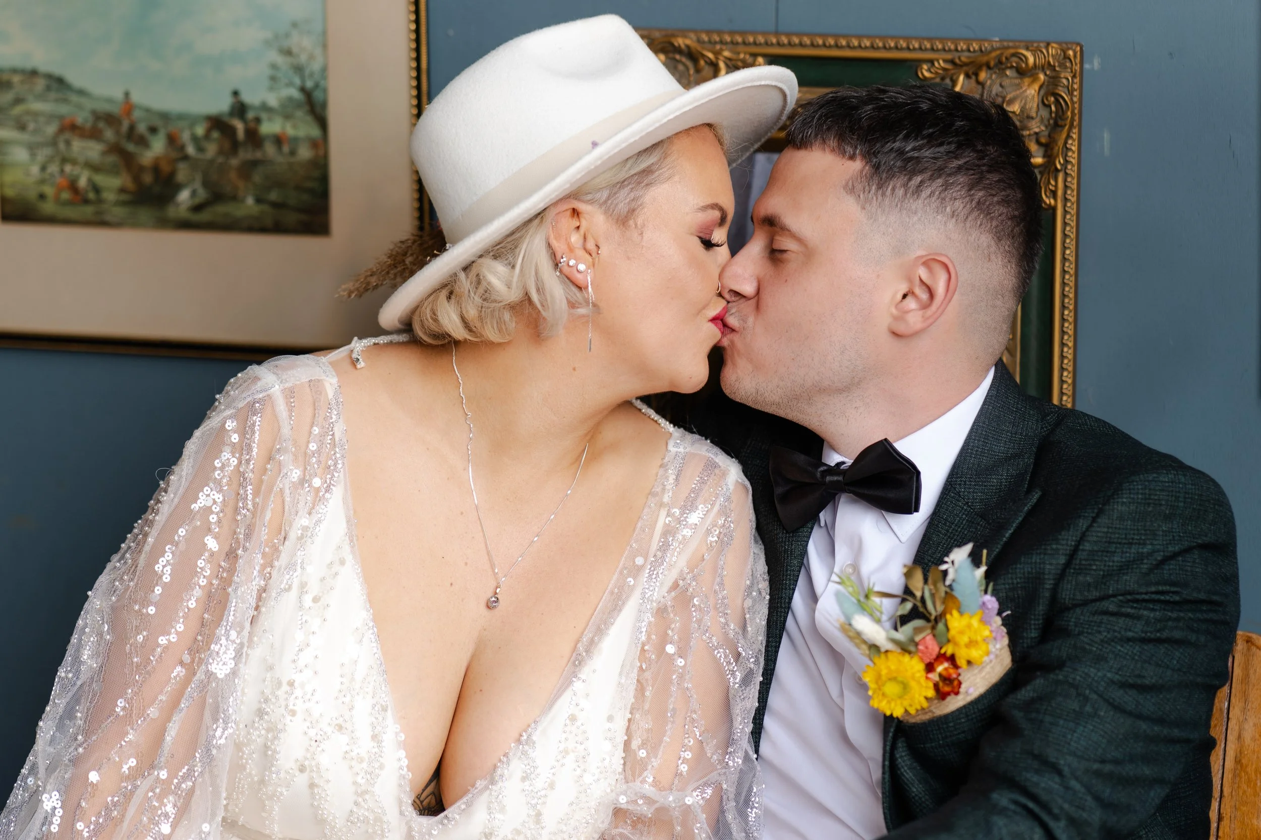 Wedding couple sitting together and sharing a kiss at a rhyse farm wedding