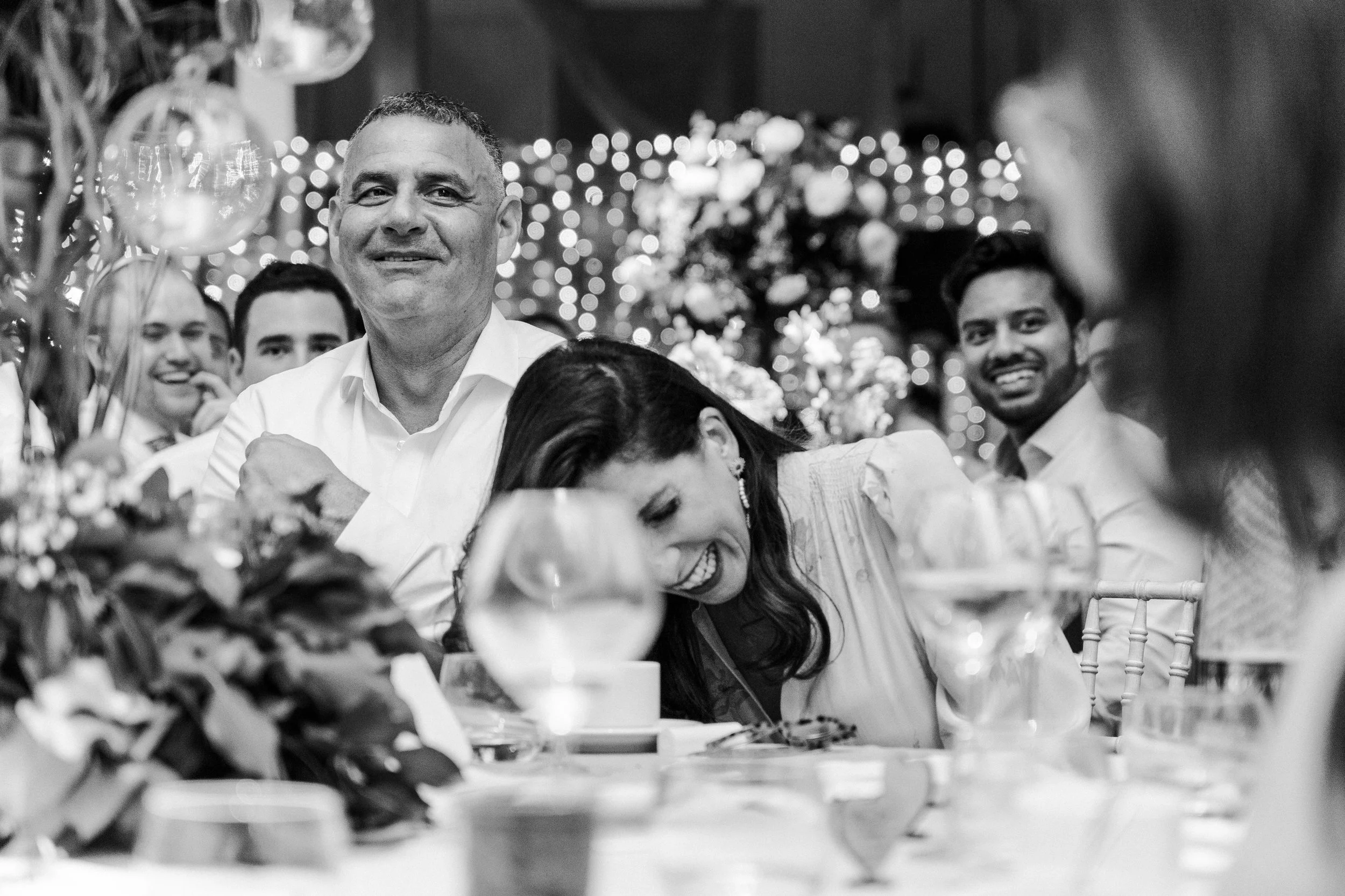 Guest laughing listening to speeches at a wedding reception at at a Micklefield Hall Wedding