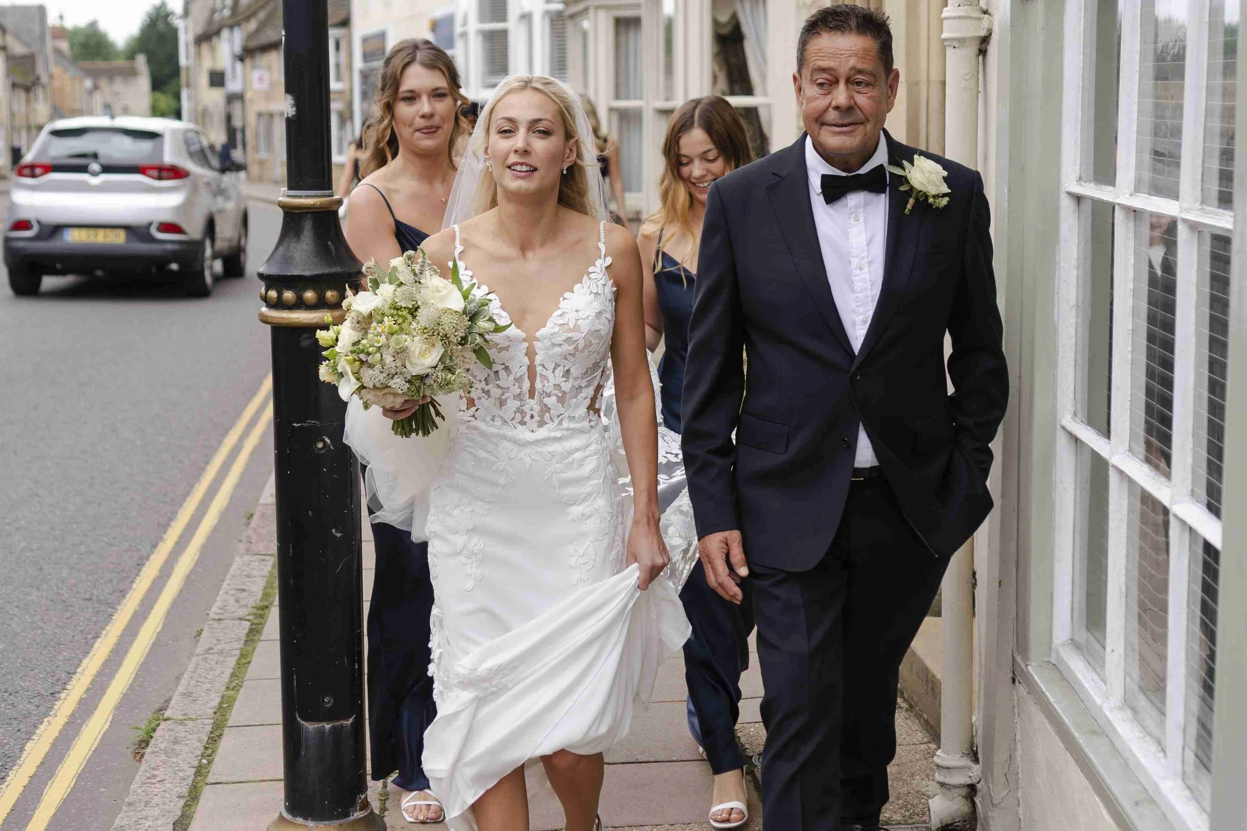 Bride with Father walking down the street to the church at the Halfmoon Farm Wedding in Rutland