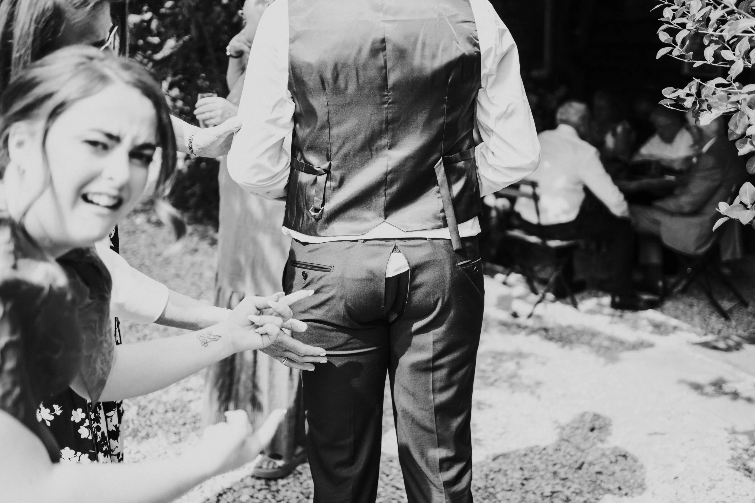 Bridesmaid showing split in her partners trousers at a Worton Kitchen Garden, Oxfordshire Wedding.