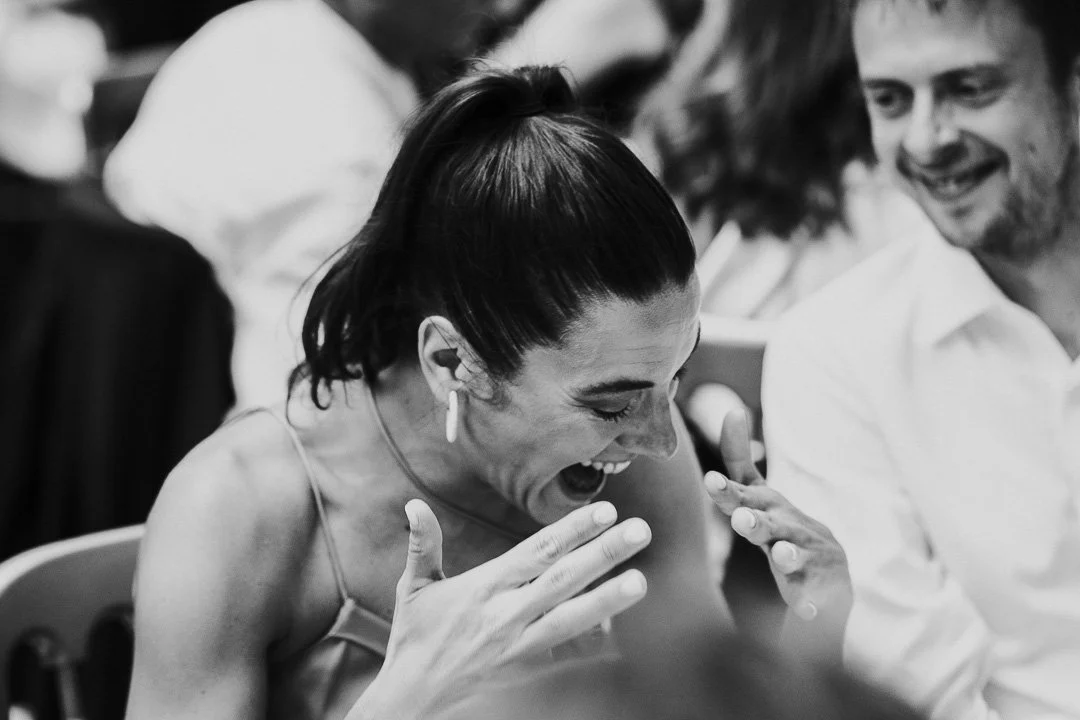A guest listening to the speeches is crying with laughter at a Hampton Court House Wedding.