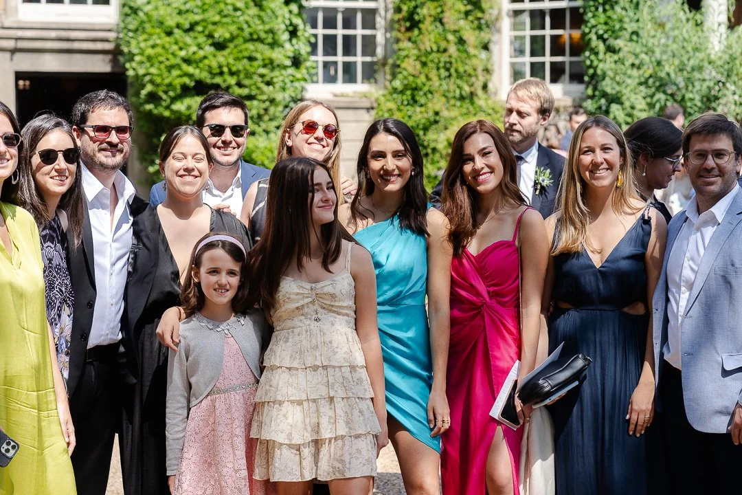 Guests lined up for a group shot with the entrance to Hampton Court House at a Surrey Wedding.