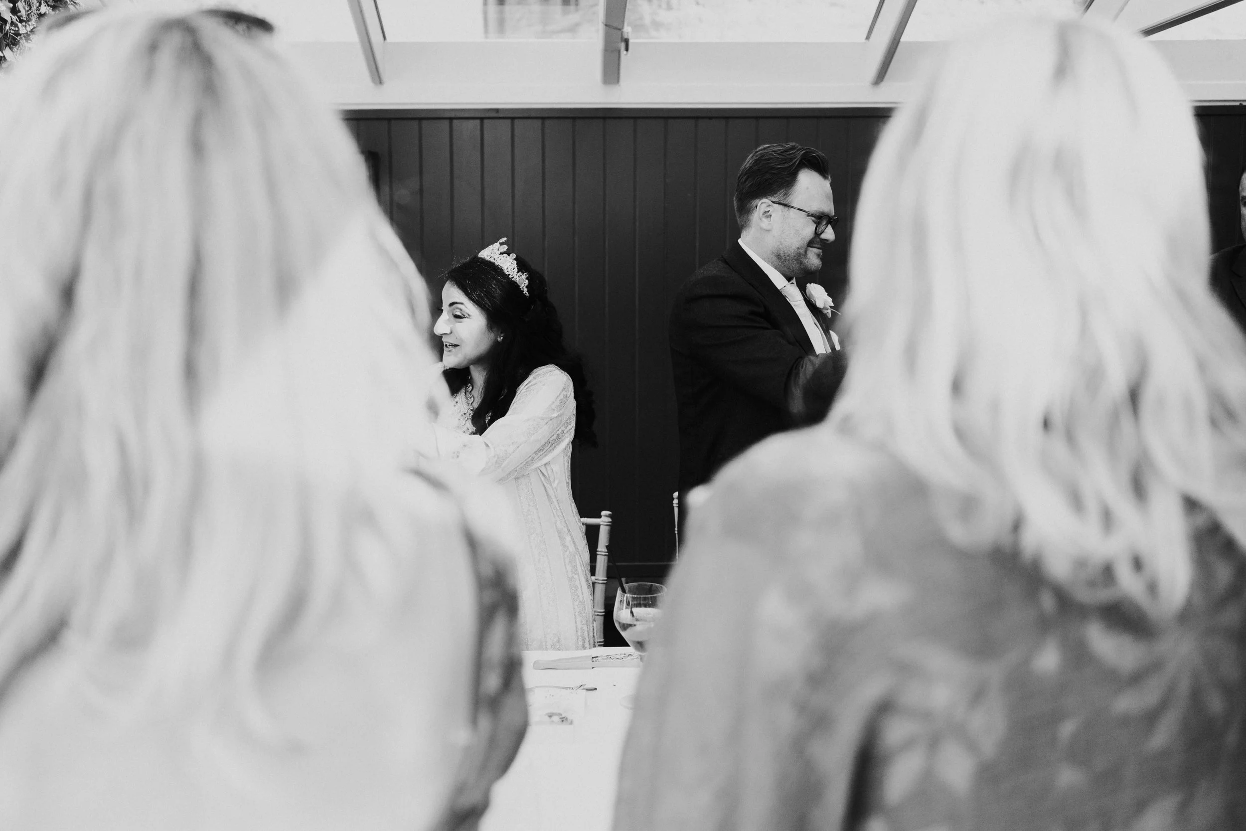 Bride & Groom facing opposite to each other speaking to guests
