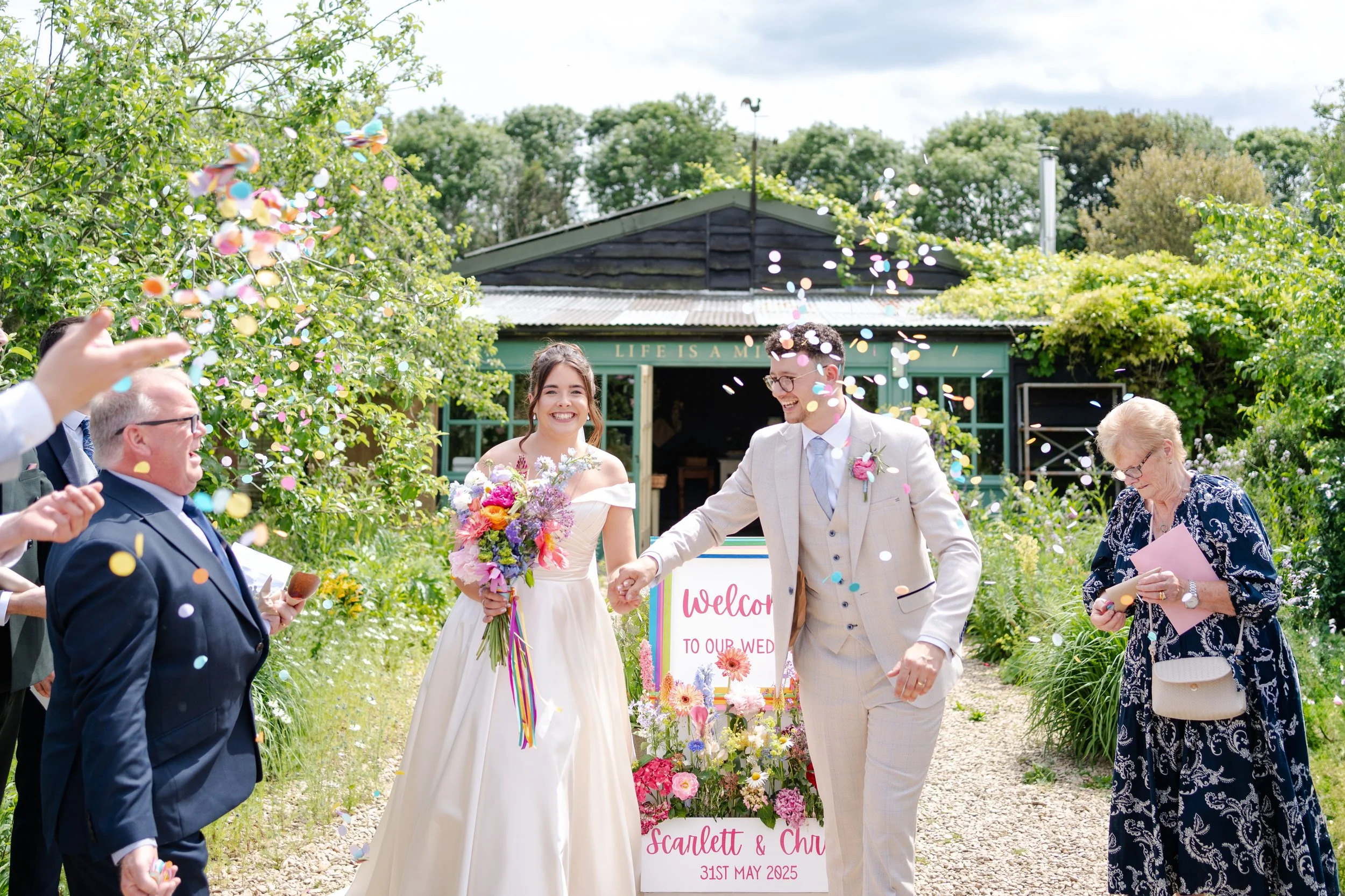 Wedding couple at the start of the confetti line at a Worton Kitchen Garden, Oxfordshire Wedding.