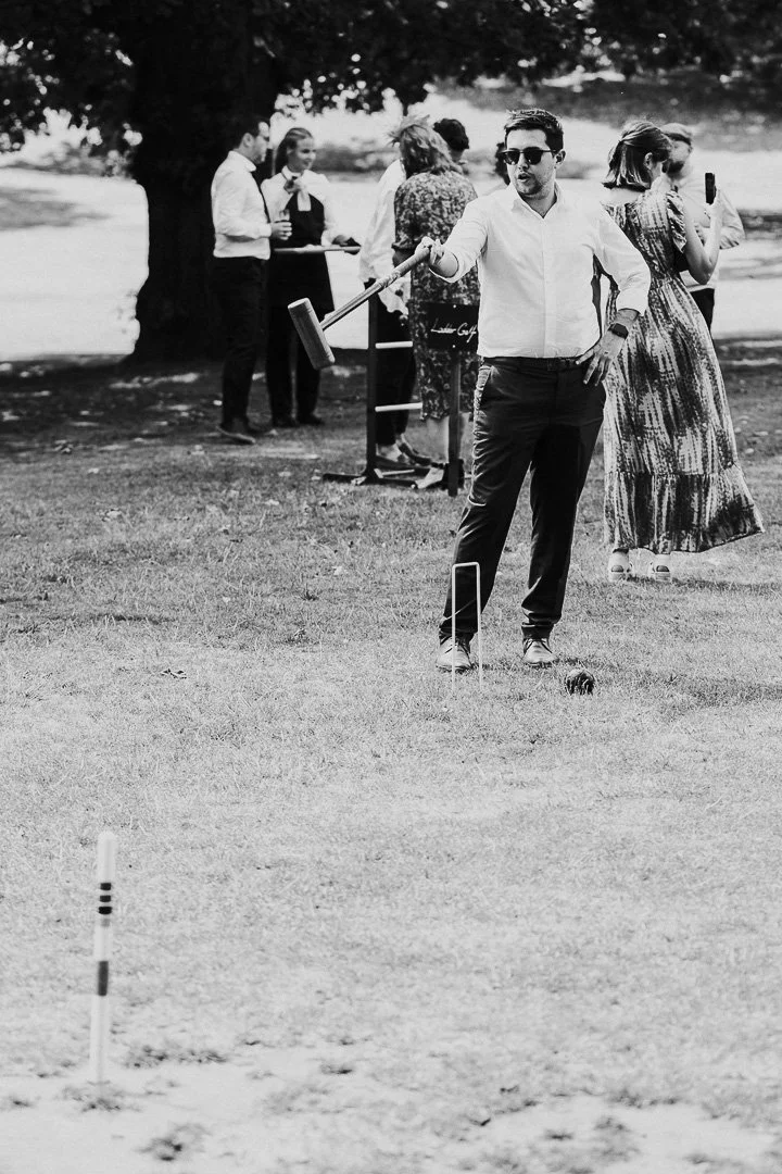 A guest sizing up his shot with his croquet mallet at a Hampton Court House Wedding.