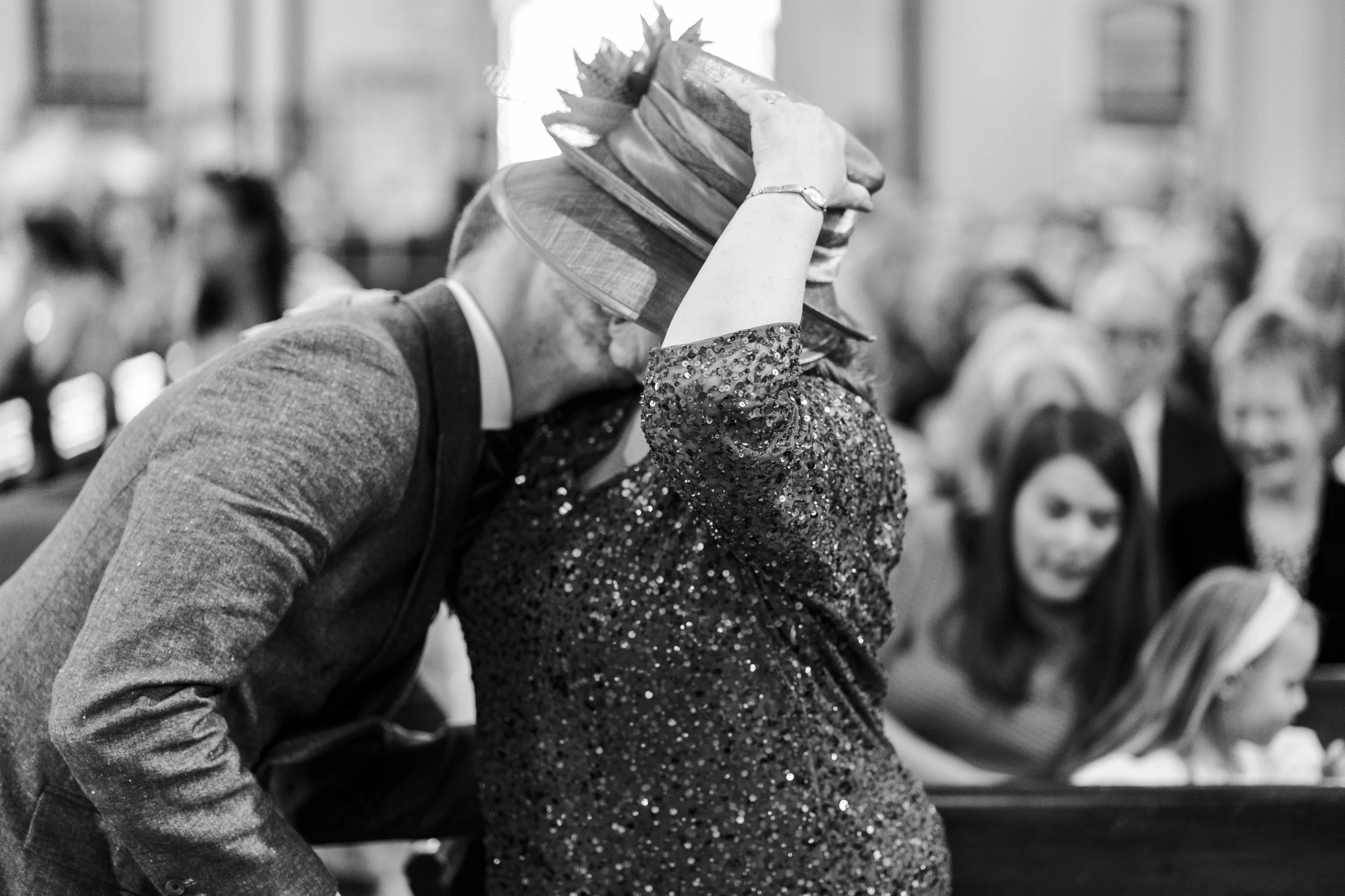 Groom kissing the Mother of the Bride crouching down to kiss her under her hat at a Highgate, London Wedding