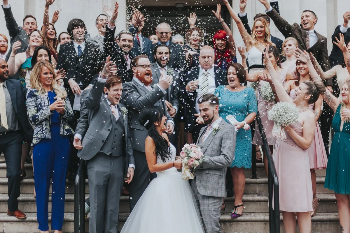 Guest showering the Bride & Groom with confetti on the steps outside Islington Town Hall Wedding Venue