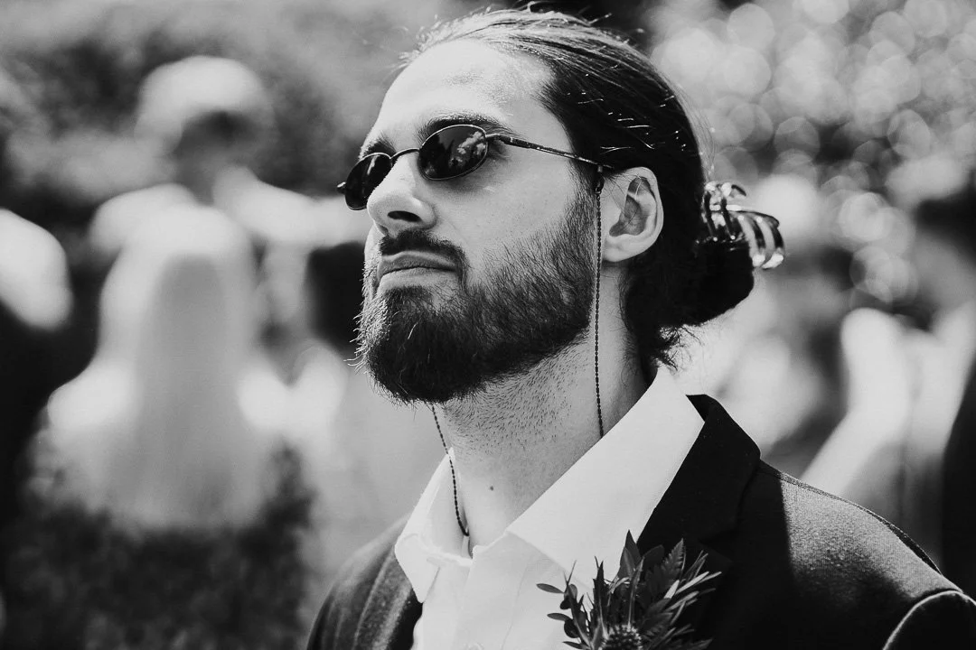 Guest wearing sunglasses looking up and away from the camera at a Hampton Court House Wedding.