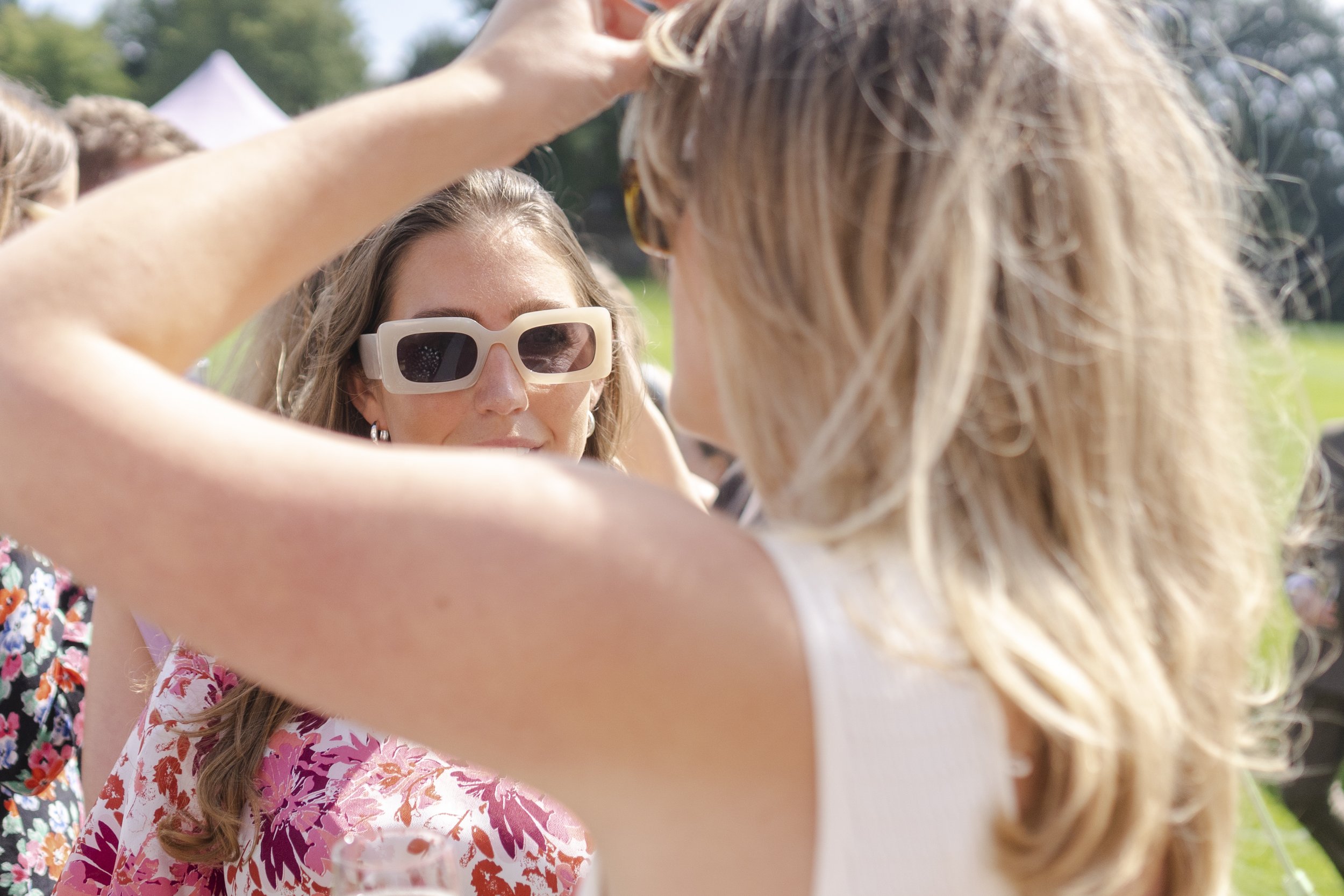 Wedding guest wearing sunglasses view through another guest arm at a Highgate, London Wedding.