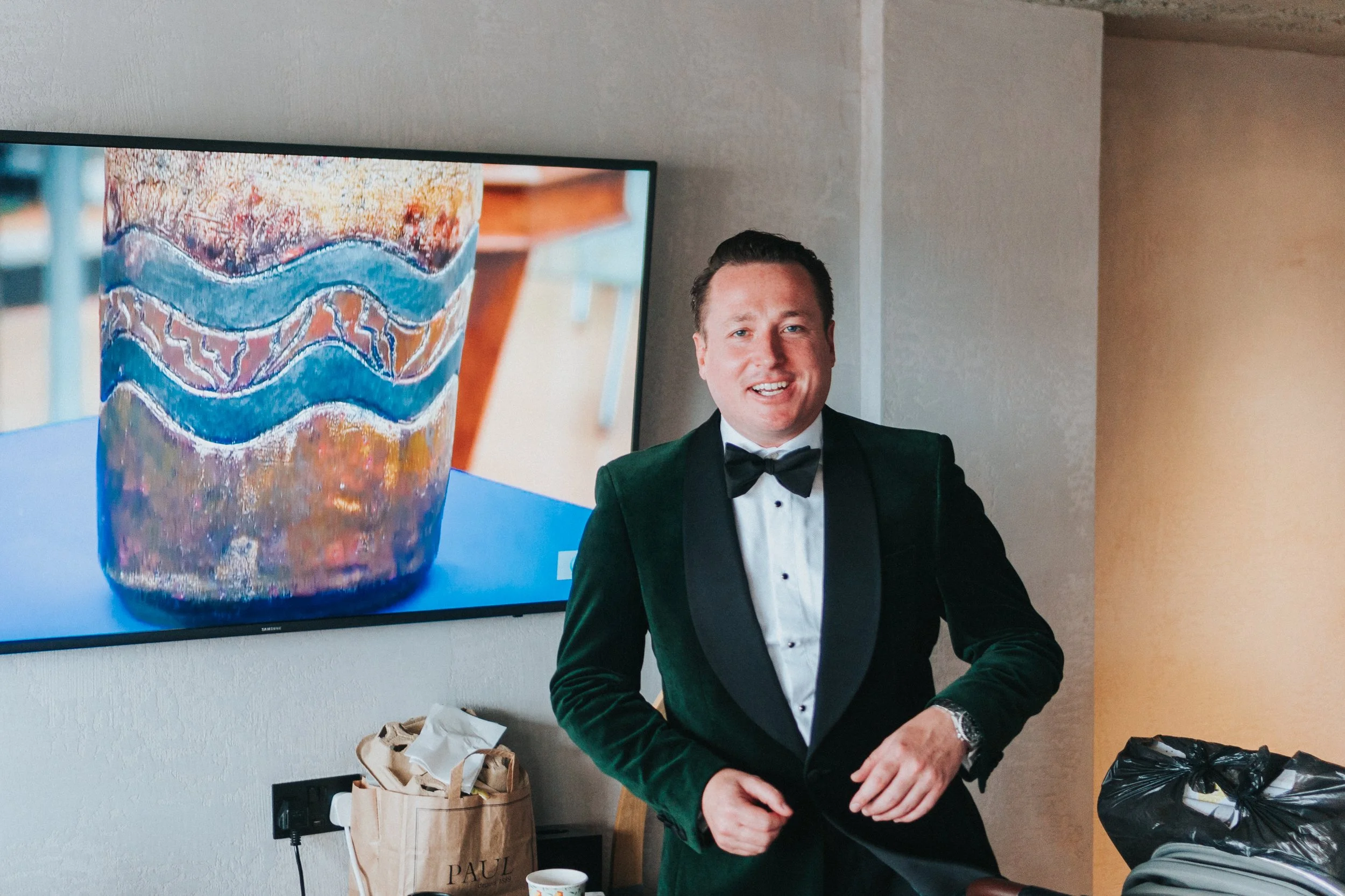 Groom buttoning up his jacket while smiling at The Treehouse, London at a Old Marylebone Town Hall Wedding