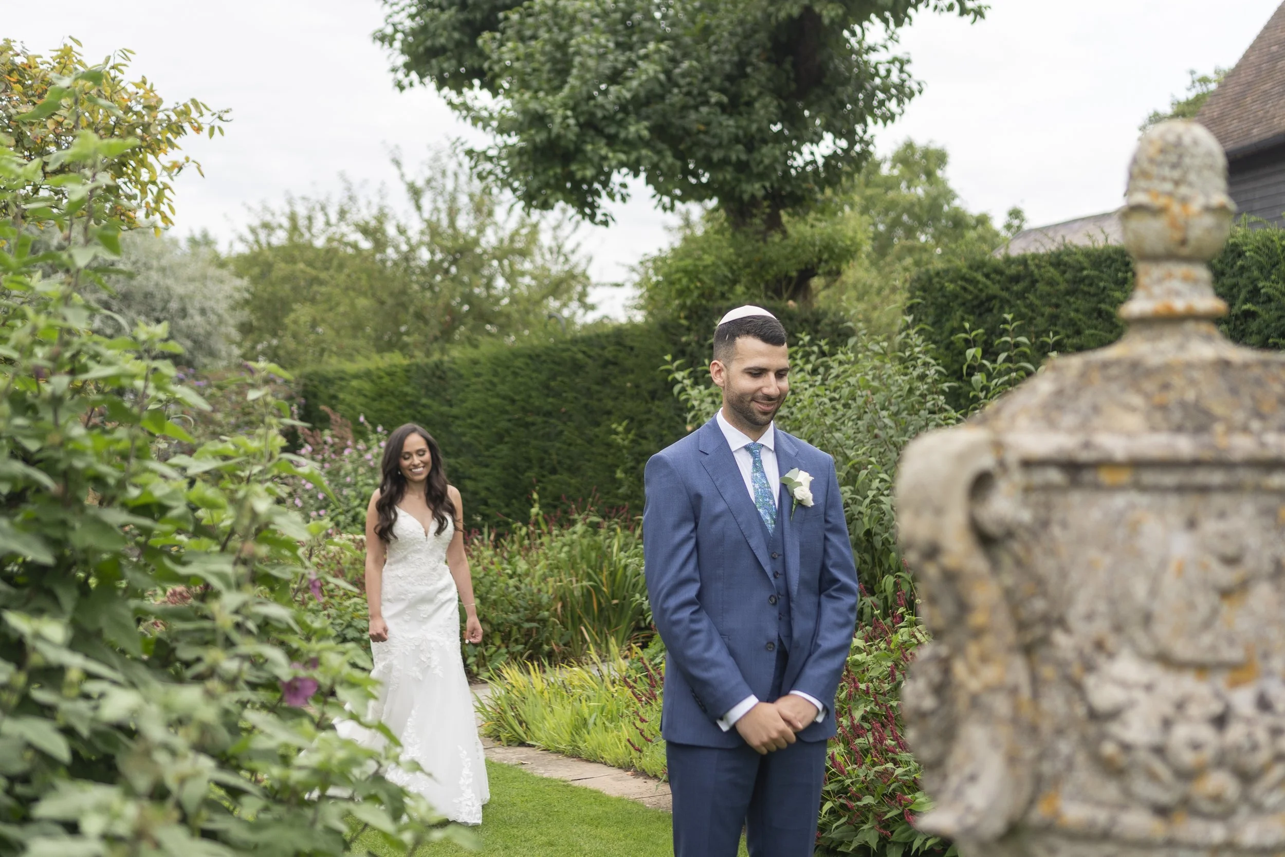 Bride walking up to the Groom from behind in the gardens for their First Look at a Micklefield Hall Wedding