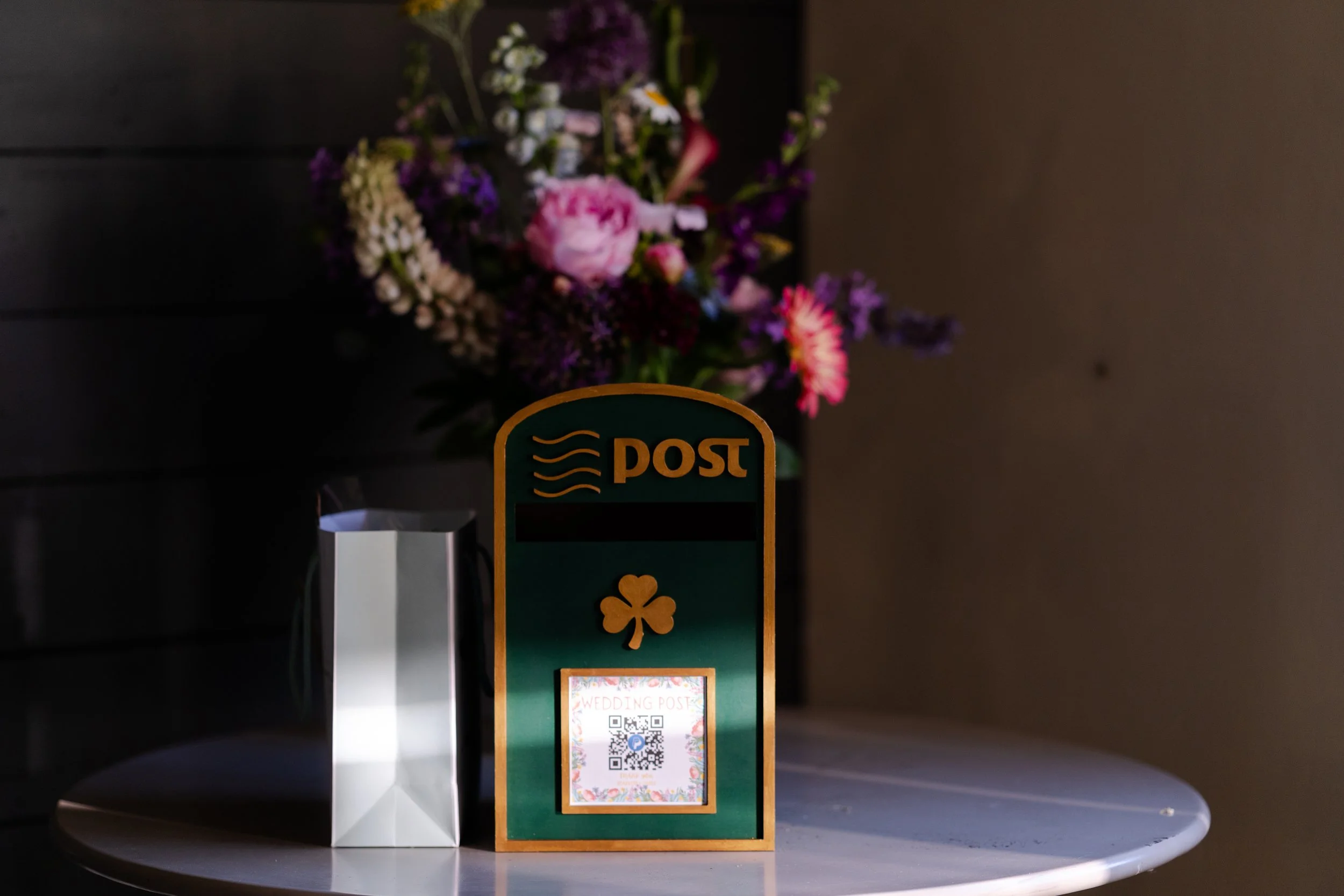 Green postbox on table with wedding gifts with harsh shadows at a Worton Kitchen Garden, Oxfordshire Wedding.