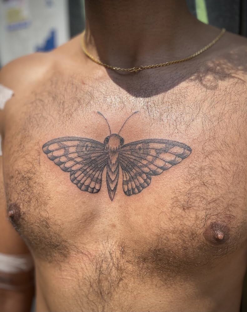 A butterfly tattoo on a man's chest.
