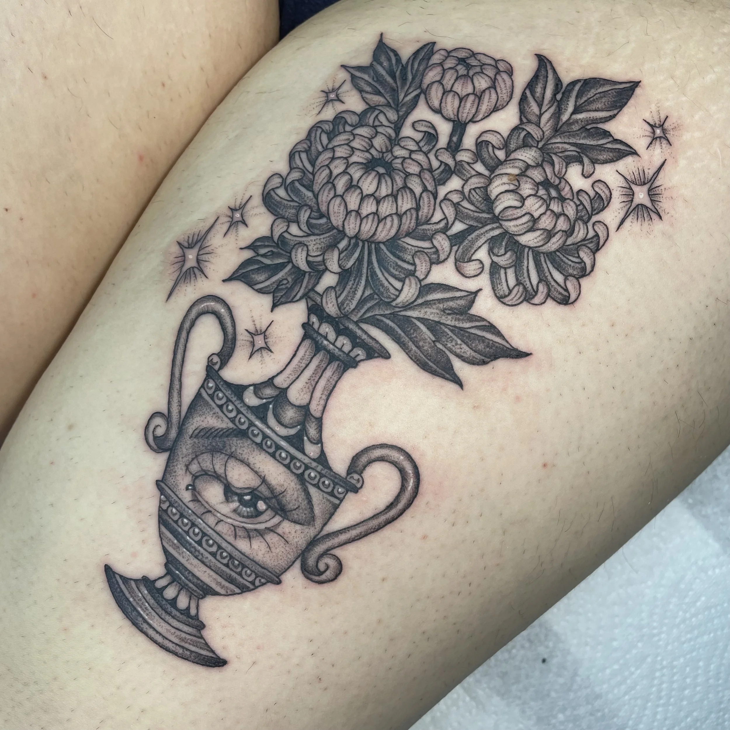 Tattoo of flowers in vase with eye design