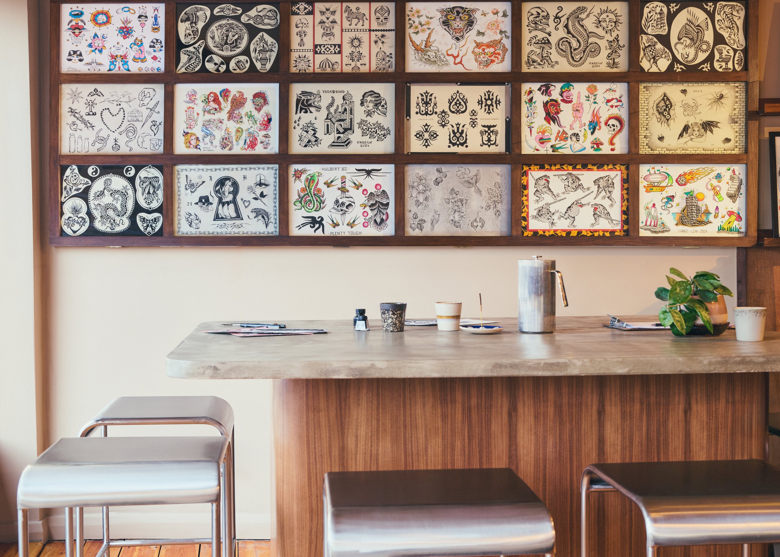 Tattoo studio with flash art on wall and studio table