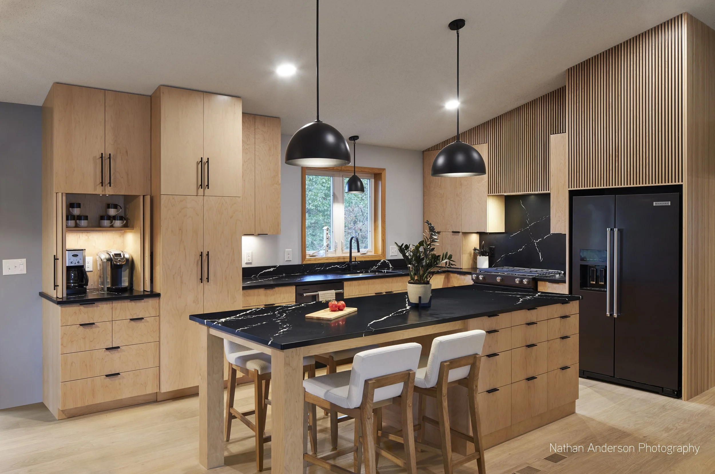 A formerly enclosed kitchen transformed into a light-filled, open gather space. The cabinets and countertops are all free from harmful chemicals, durable, and cost less than traditional enameled cabinets.