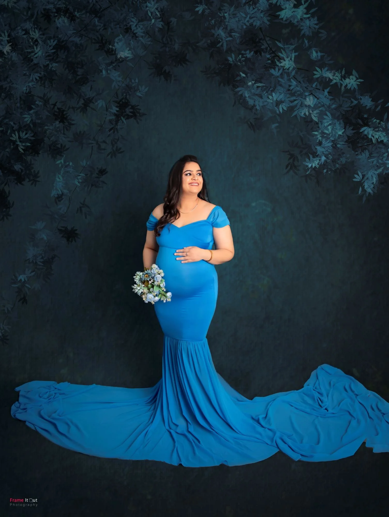 Low-angle maternity portrait emphasizing gown and belly