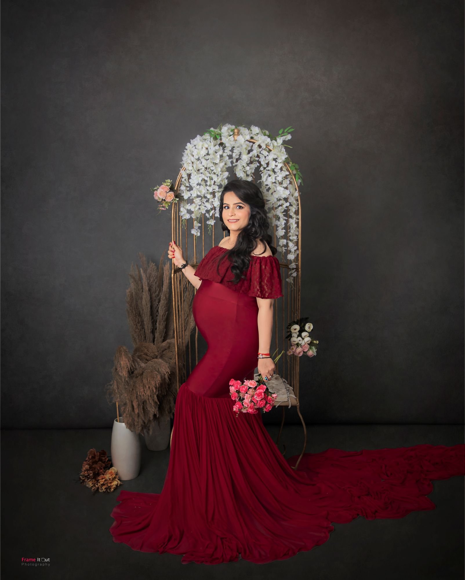 Studio maternity photo of expecting mother in a fitted gown with soft lighting