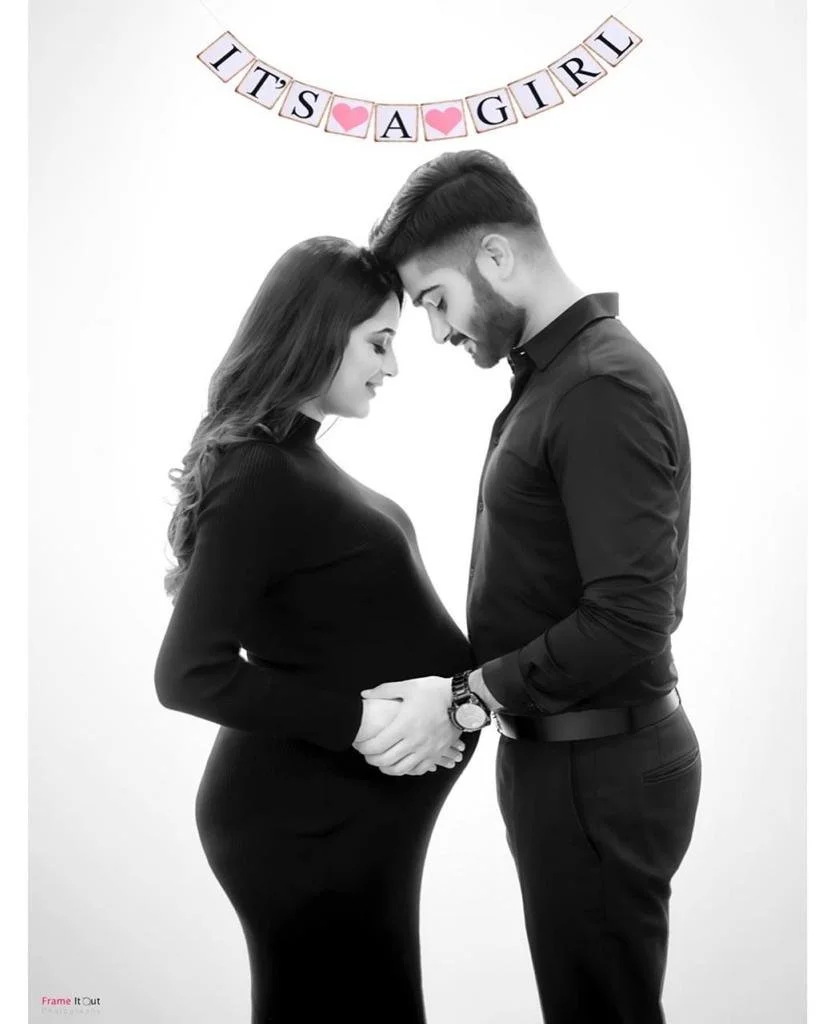 Elegant black and white maternity portrait of expecting mother holding her bump
