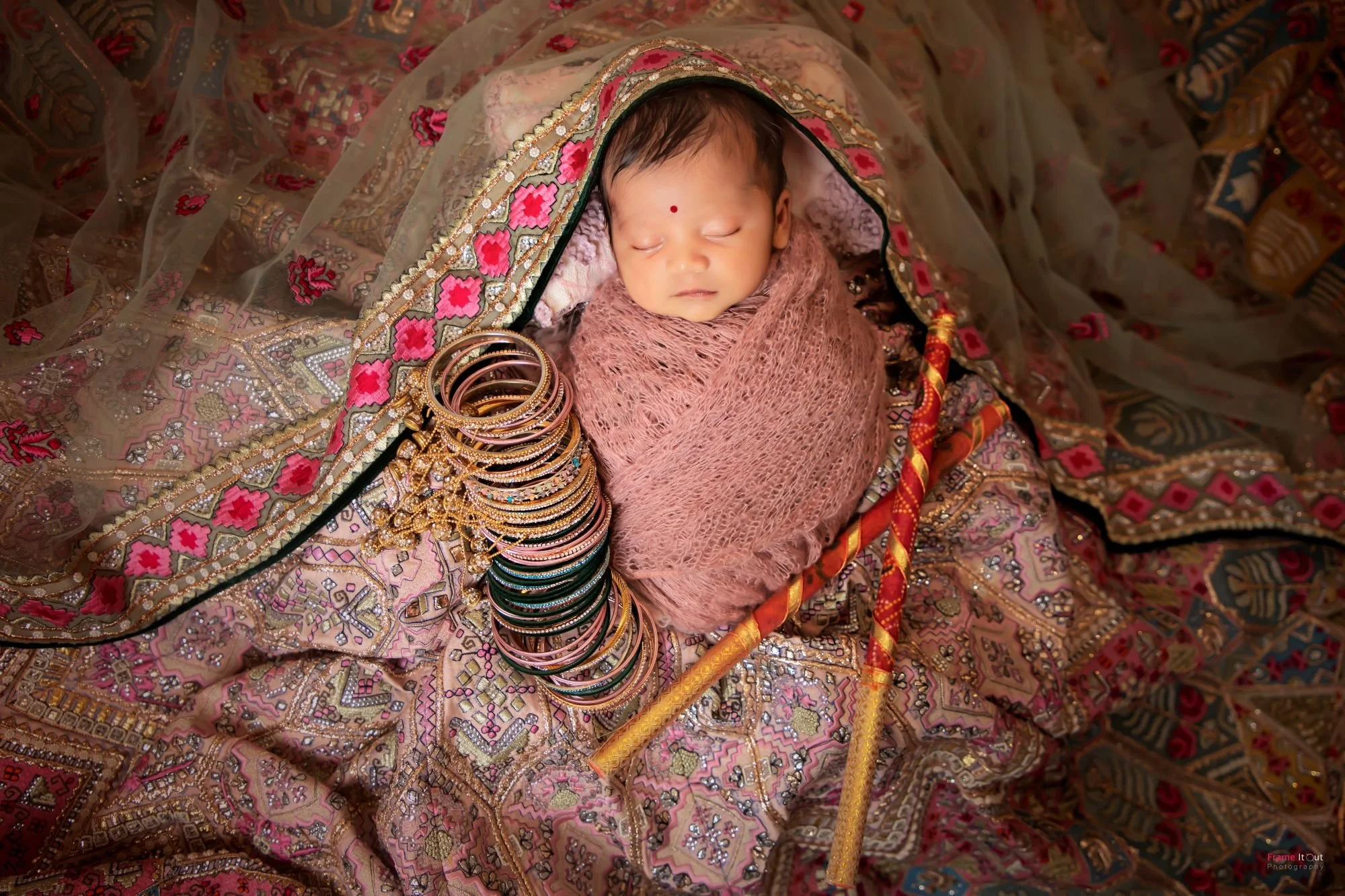 Fine art newborn photography featuring a beautifully wrapped baby
