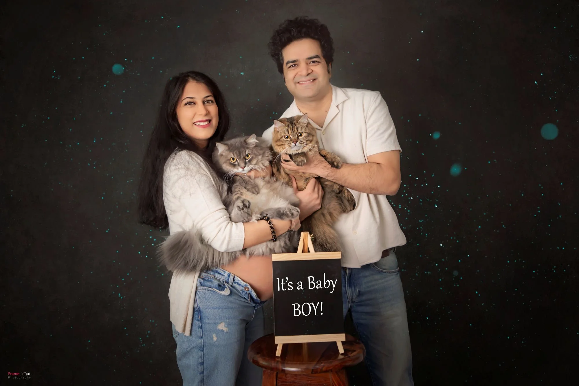 Maternity photo of couple holding their pet cat during studio pregnancy session
