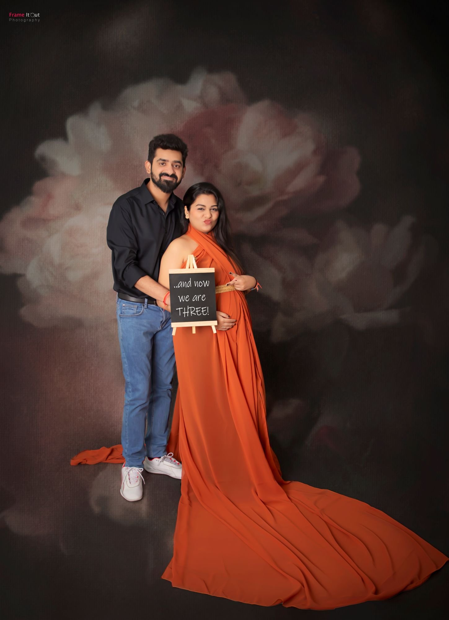 Maternity session photo of couple holding ‘It’s a Girl’ banner during pregnancy reveal
