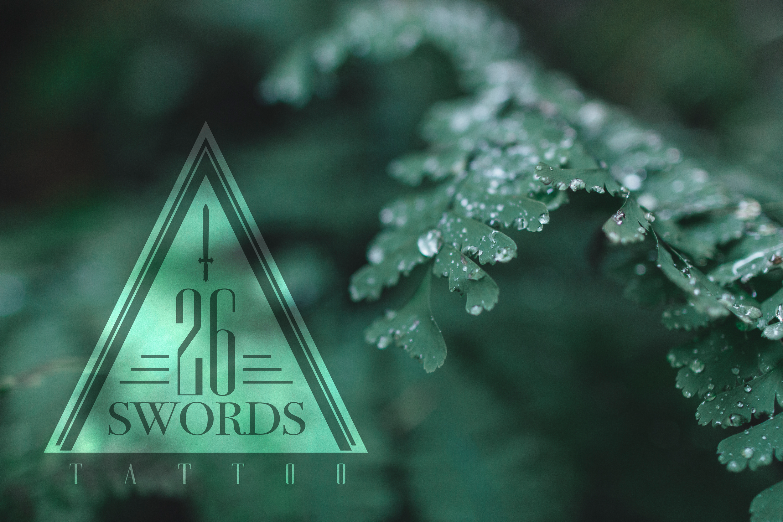 Close-up of green fern leaves with water droplets, branded with 26 Swords Tattoo logo