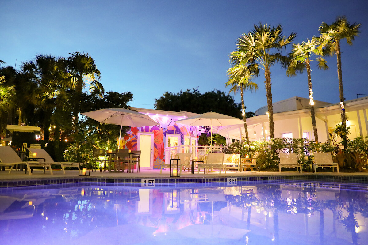 pool lit up at night of orchid key inn, purple and romantic