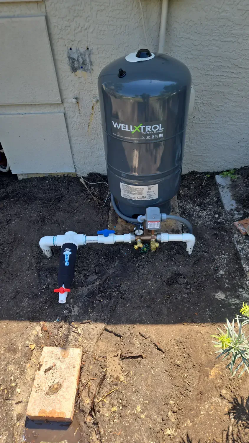 Well pump repair with a pressure tank mounted at the building wall