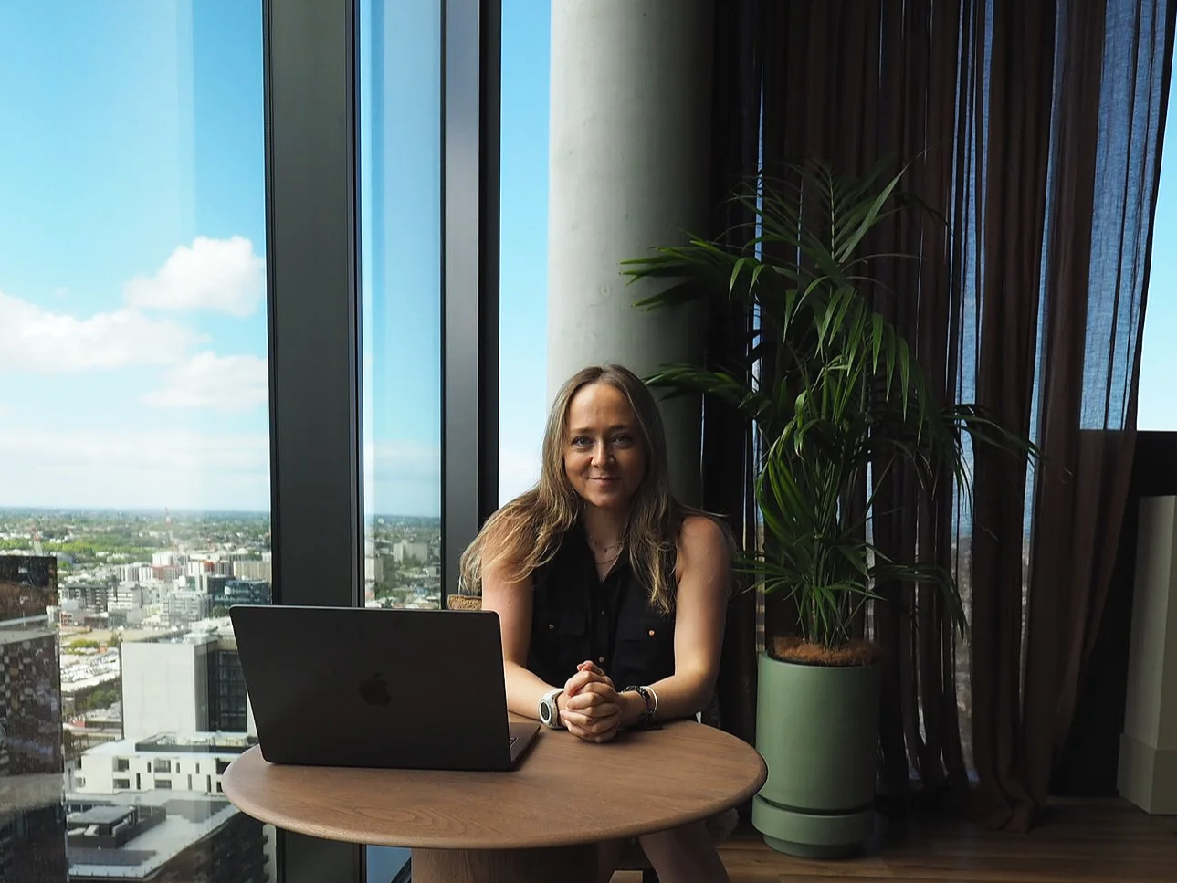 Digital strategist working on a laptop with a city skyline view