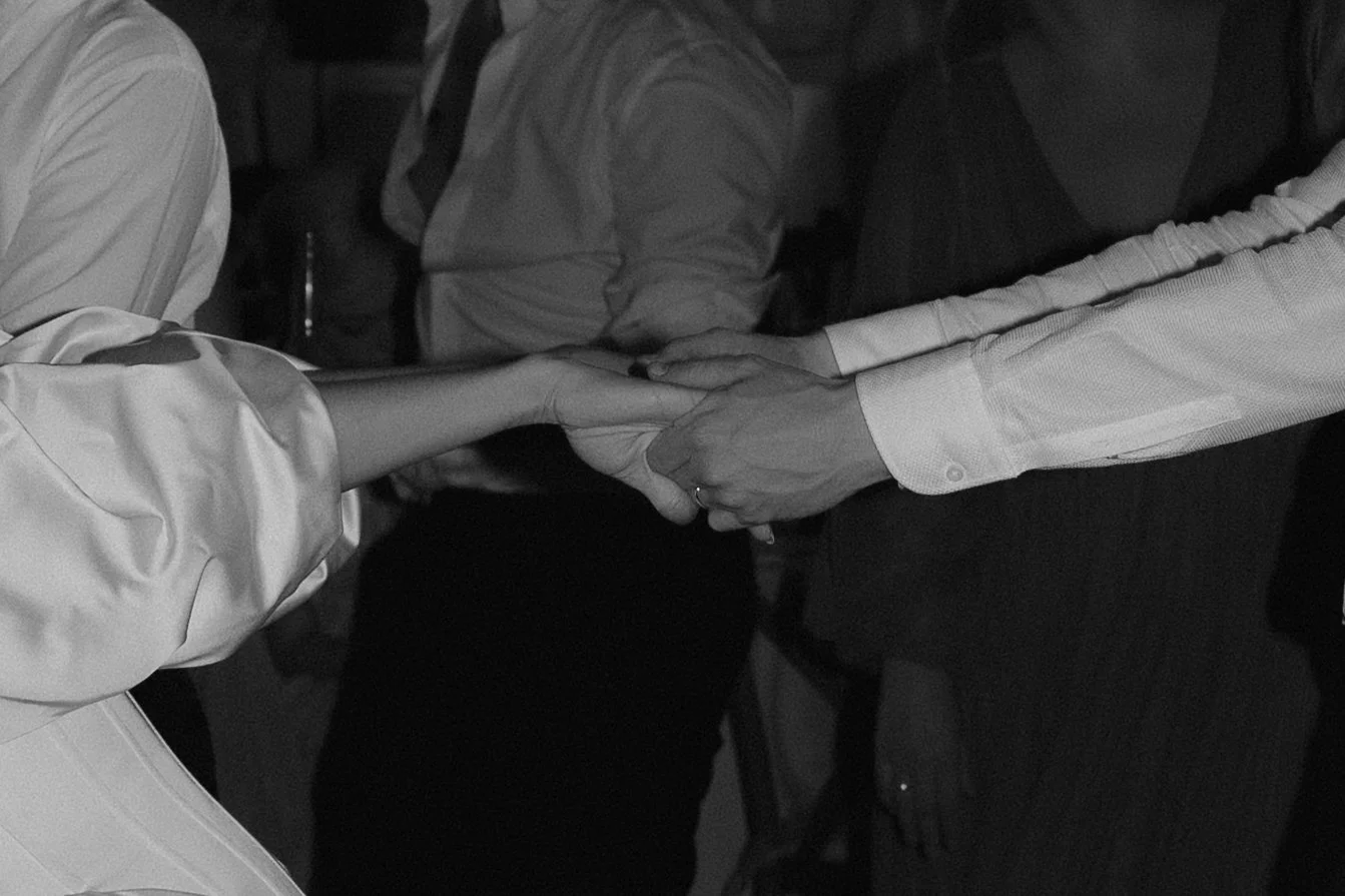 People holding hands at a gathering or event.