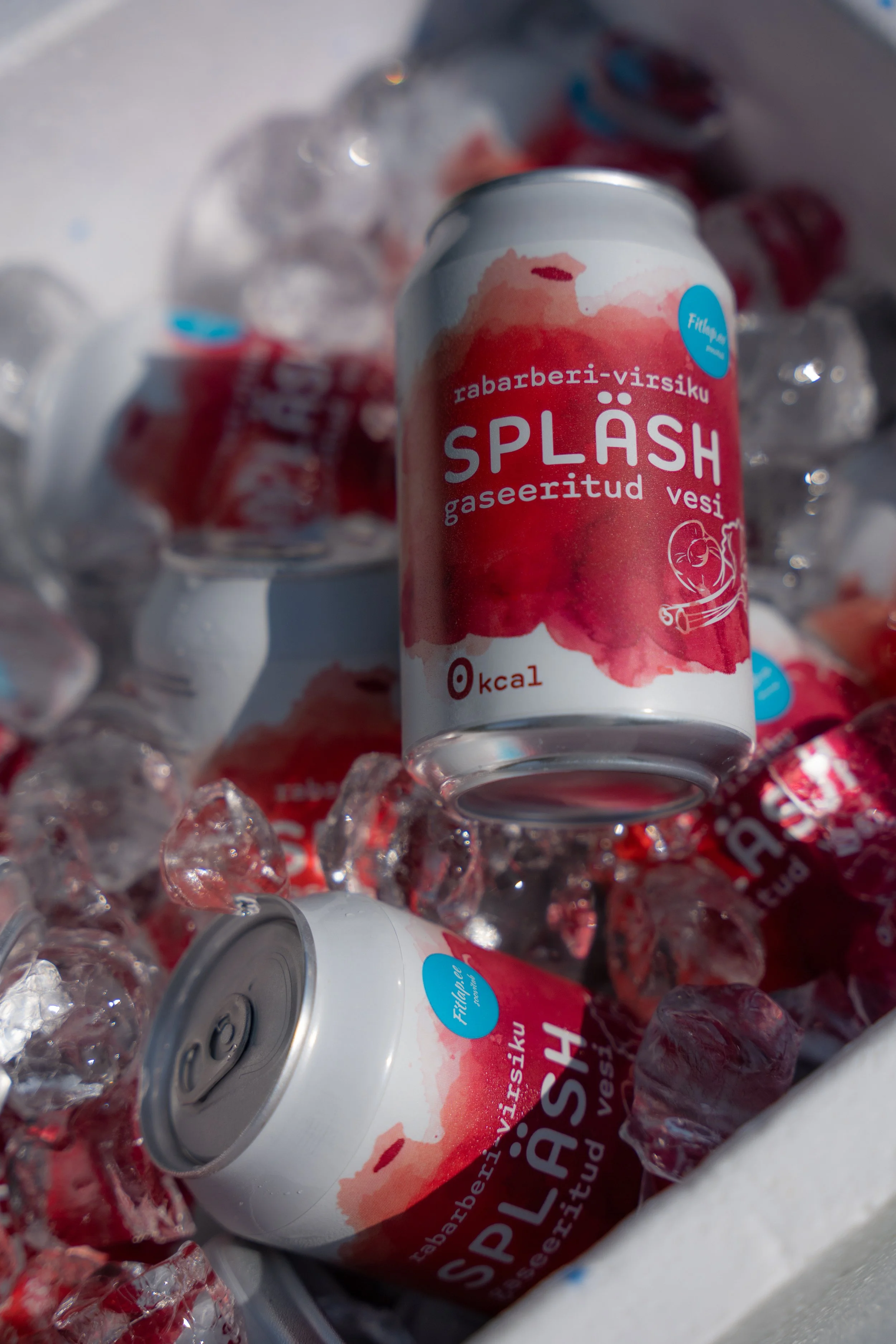 Aluminum cans of a beverage called Splash with Estonian language label, surrounded by ice cubes.