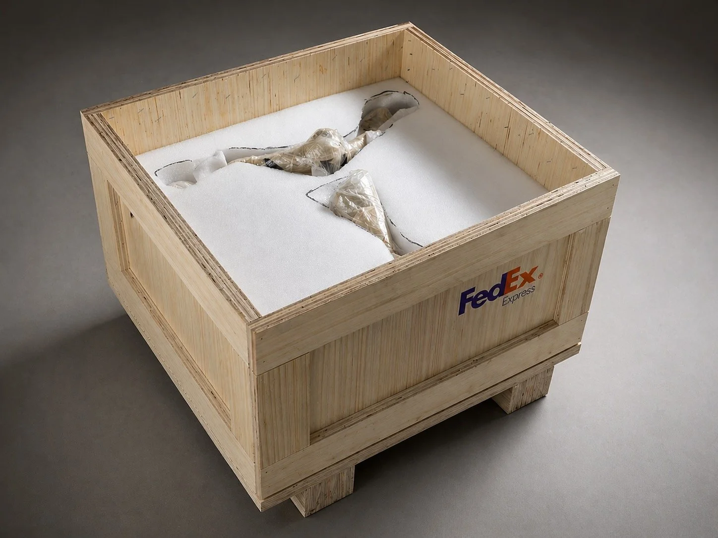 A wooden FedEx Express shipping crate with a foam interior and a broken ceramic model inside.