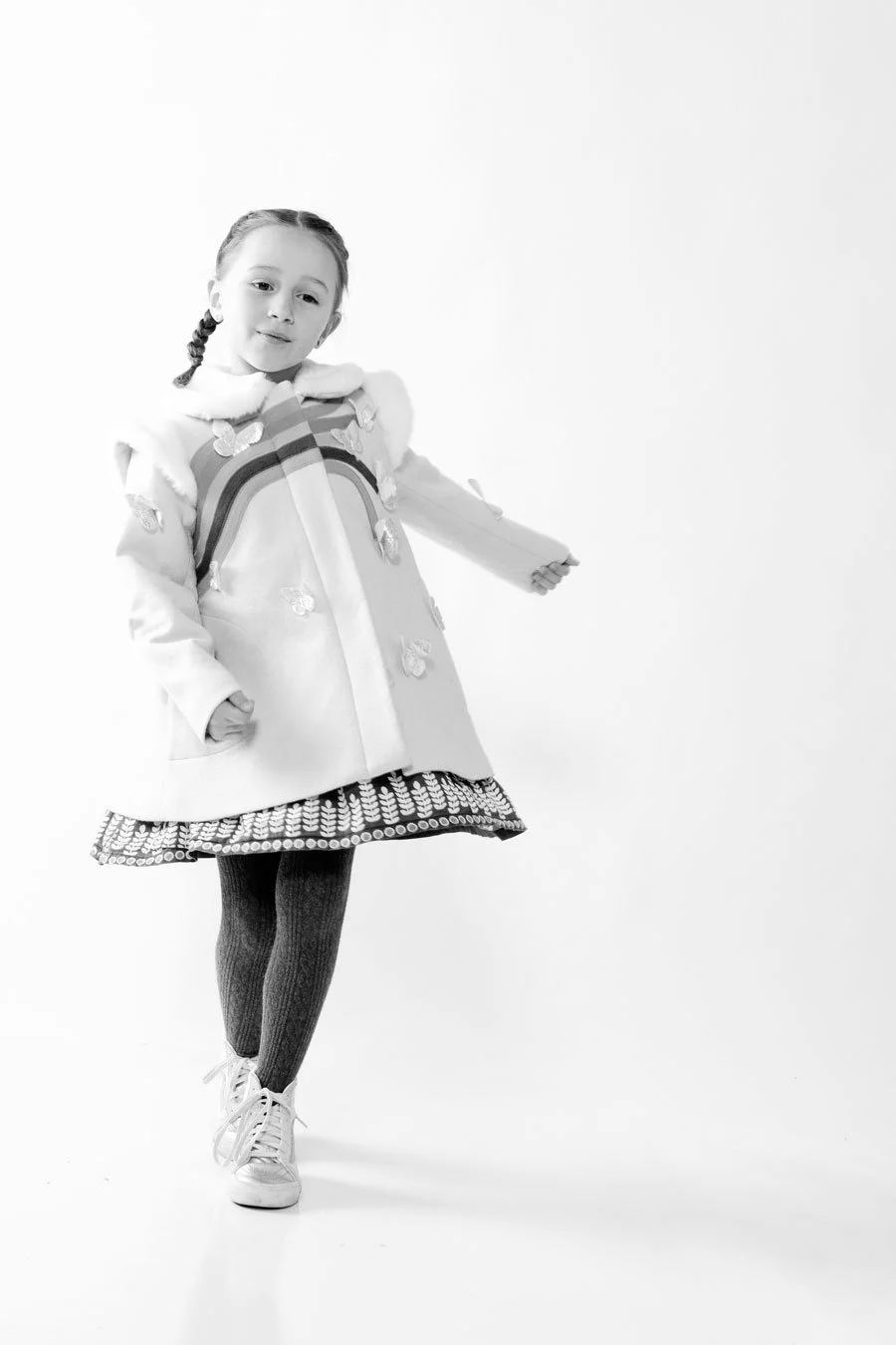little girl in dressy coat dancing. black and white image on white background. portsmouth NH