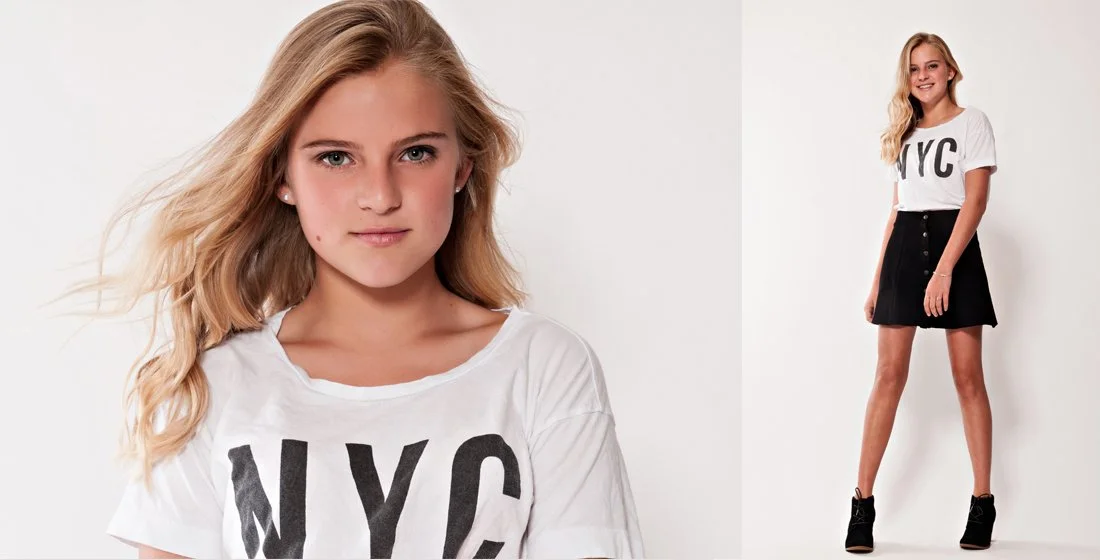 Young blonde girl on a white background, wearing a white T-shirt that has NYC with big black letters on it. Wind blown hair. Portsmouth NH