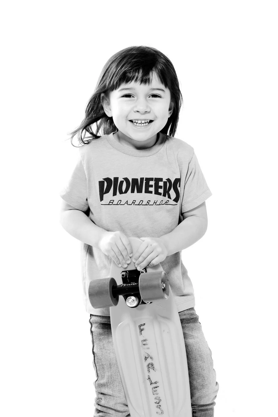 little girl with dark hair holding a skateboard, black and white image on white background. Portsmouth NH