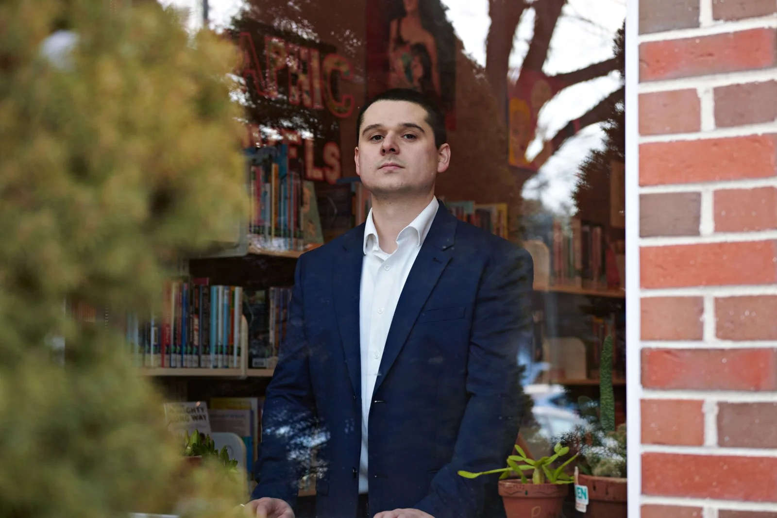 Editorial portrait. branding portrait. serious man inside a building through a reflective window. Portsmouth NH, seacoast NH