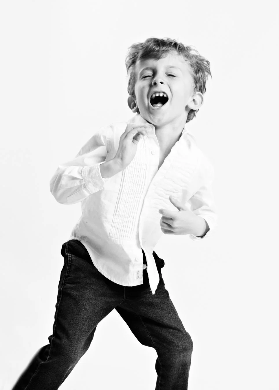 little boy dancing with emotion. eyes closed. mouth open. black and white image on white background. portsmouth NH